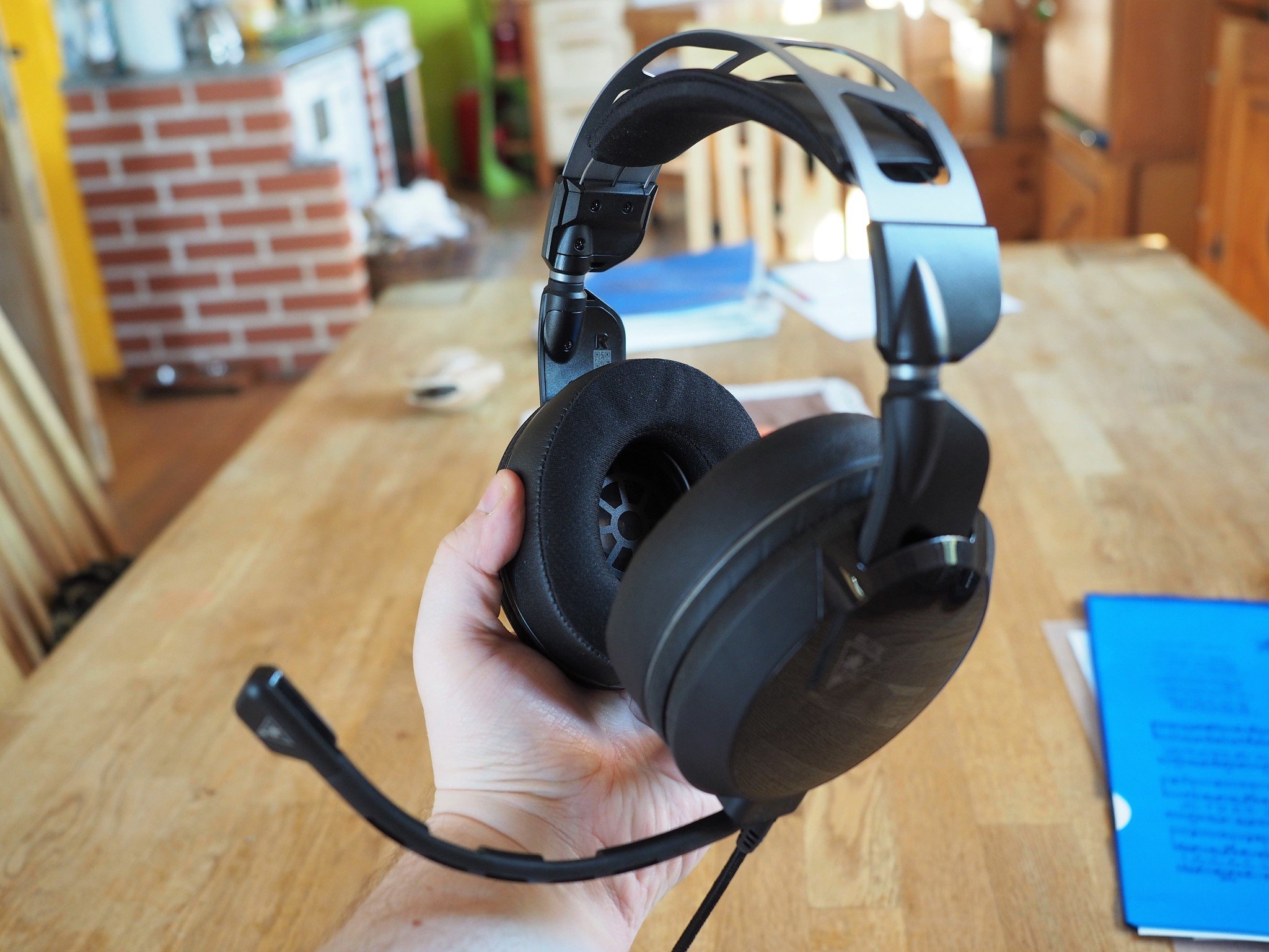 The Turtle Beach Elite Atlas headset it held in an outstretched hand. 